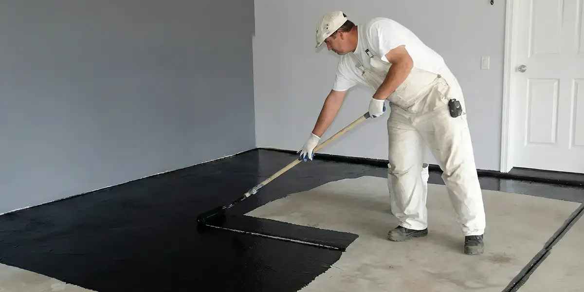 basement waterproofing professional applying waterproof coating to protect a basement floor in Fort Collins, CO